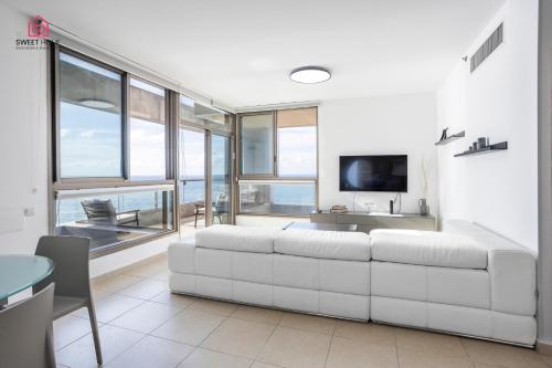 a living room with a white couch and a tv at Luxury apartments' in Netanya in Netanya