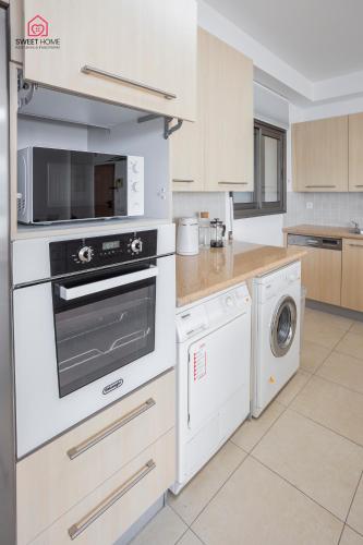 a kitchen with a stove and a washer and dryer at Luxury apartments' in Netanya in Netanya