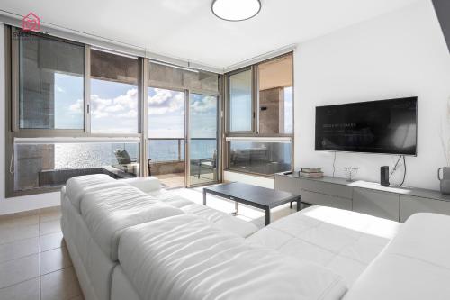 a living room with a white couch and a tv at Luxury apartments' in Netanya in Netanya