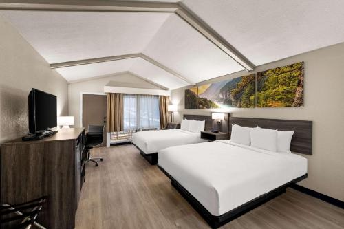 um quarto de hotel com duas camas e uma televisão de ecrã plano em Clarion Pointe Rhinelander Downtown em Rhinelander