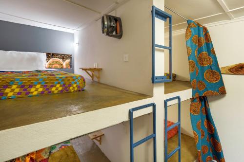 a small room with a bed and a window at Victoria Falls Backpackers Zambia in Livingstone