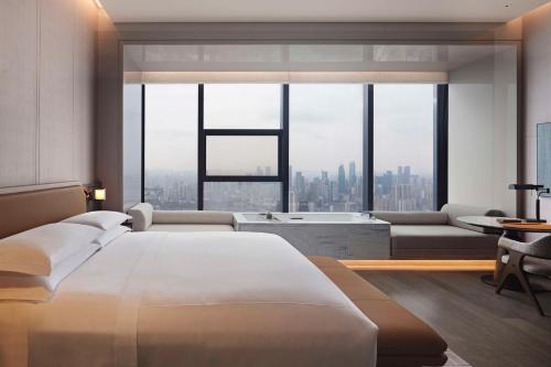 a bedroom with a large bed and a large window at Conrad Chongqing in Chongqing