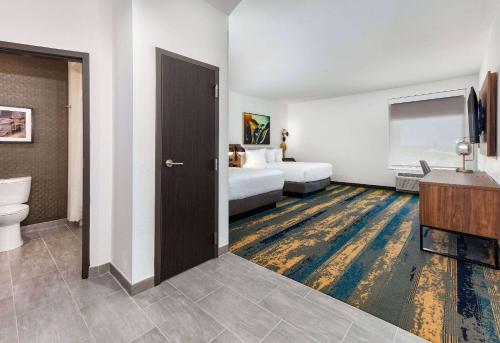 a hotel room with a bed and a bathroom at La Quinta Inn & Suites by Wyndham Terrell in Terrell
