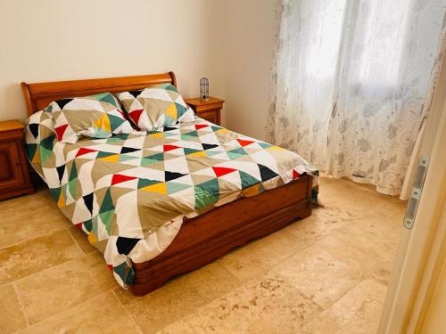 une chambre avec un lit avec une couette colorée dans l'établissement Villa à Montmirat, à Montmirat