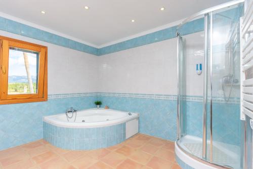 La salle de bains est pourvue d'une baignoire et d'une douche en verre. dans l'établissement Es Garroveret, à Marratxí 