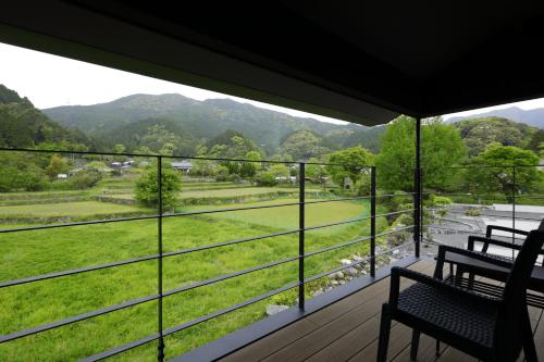 a balcony with two benches and a view of a valley at Akizukinoyado Tsuki No Hanare in Asakura