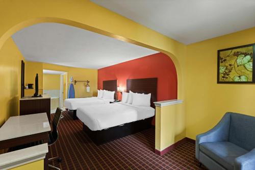 une chambre d'hôtel avec deux lits et un canapé dans l'établissement SureStay by Best Western Gulfport, à Gulfport