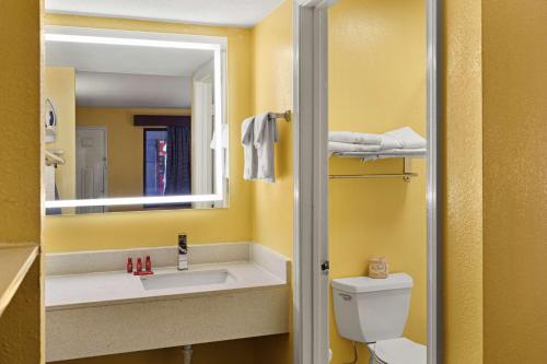 La salle de bains est pourvue d'un lavabo, de toilettes et d'un miroir. dans l'établissement SureStay by Best Western Gulfport, à Gulfport