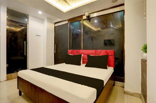 a bedroom with a large bed with a red headboard at OYO Kashish Residency in New Delhi