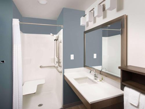 a bathroom with a sink and a mirror at WoodSpring Suites Huntsville - Research Park in Huntsville