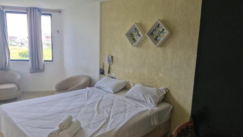 a bedroom with a bed with white sheets and pillows at VICTORY FLAT-APTO 207 in Cabedelo