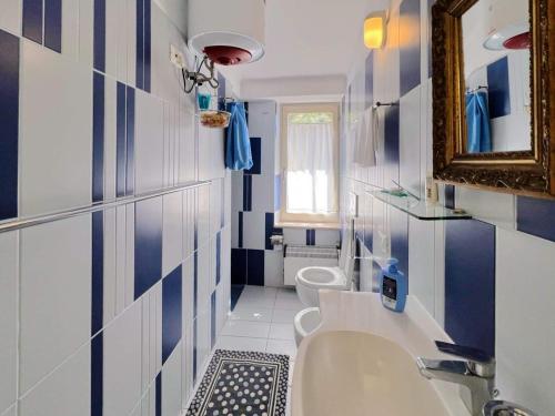 een blauwe en witte badkamer met een wastafel en een toilet bij La casa di Piermaria in Varazze