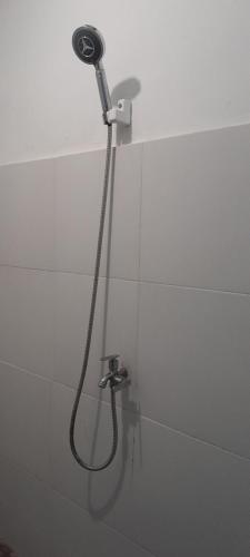 a shower with a hose attached to a wall at Romantic Homestay in Kuta Lombok