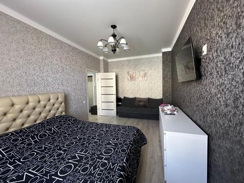 a bedroom with a bed and a couch at 1 комн.квартира in Balqash