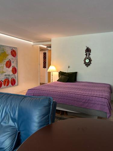 een slaapkamer met een bed met paarse lakens en een bank bij GETGYR Hostel in Holbæk