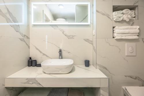a white bathroom with a sink and a toilet at Delux apartments Selina in Baška Voda