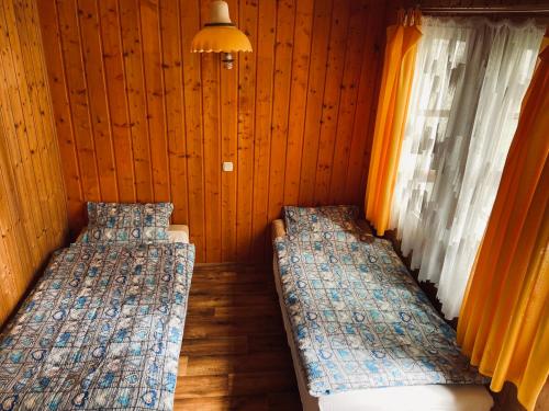 a room with two beds and a window at Domki letniskowe in Śliwin