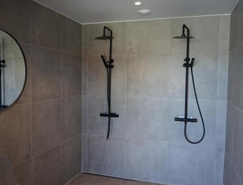 a bathroom with a shower with four hoses at Orkla Camping in Orkanger