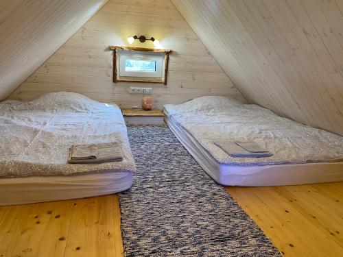 two twin beds in a attic bedroom with a rug at Reiu majake in Reiu