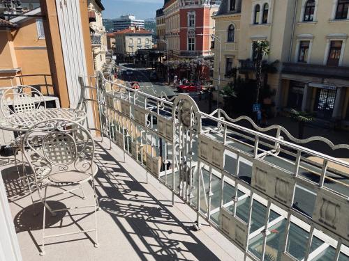 a balcony with a table and chairs on a city street at Apartment Abbazia in Opatija
