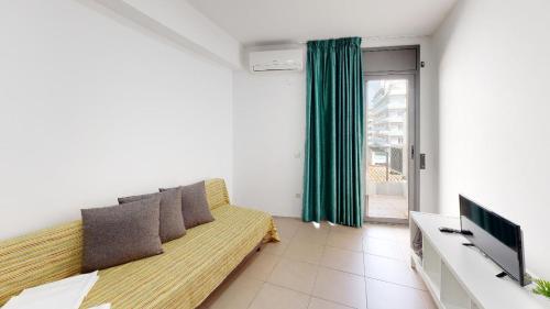 un soggiorno con divano e TV di Apartments Summer Dreams a Lloret de Mar