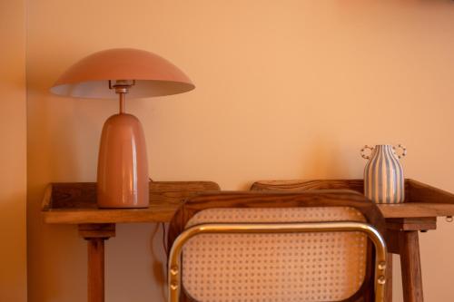 a wooden table with a lamp and a chair at Boutique Hôtel La Baignoire in Lacanau-Océan