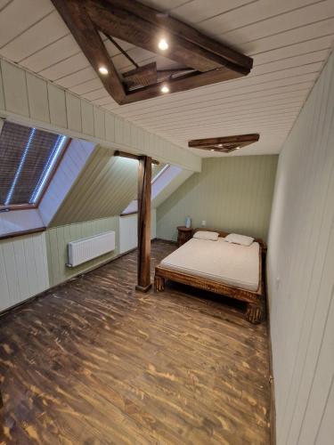 a attic room with a bed and a window at Bajāri - Viesu Māja in Svente