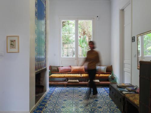 巴塞隆納的住宿－Verdi 254，一个人在带沙发的客厅里散步