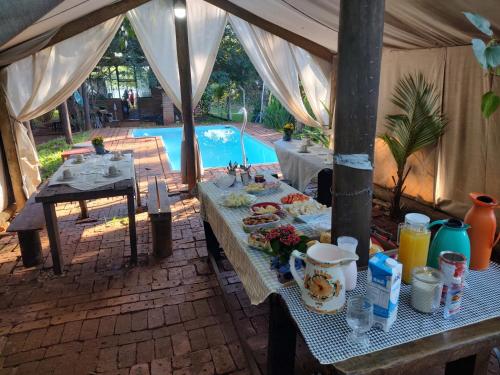 un tavolo con cibo sopra in una tenda con piscina di Trailer de Viagem no Rancho Santo Sol a Pederneiras