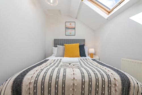 - une chambre avec un grand lit et un oreiller jaune dans l'établissement Cozy 2BR | Near city | WiFi, à Cardiff