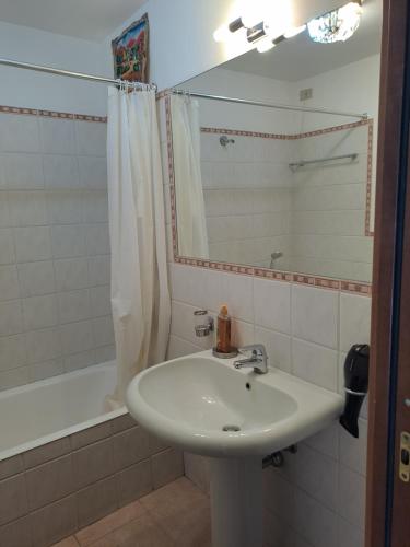 bagno con lavandino, vasca e specchio di Appartamento Via Comune Antico a Milano