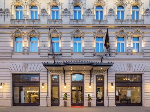 a building with blue windows on a street at Hotel Nemzeti Budapest - MGallery in Budapest