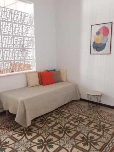 ein Sofa in einem Zimmer mit einem Fenster und einem Teppich in der Unterkunft Liberty Apartment in Galatone