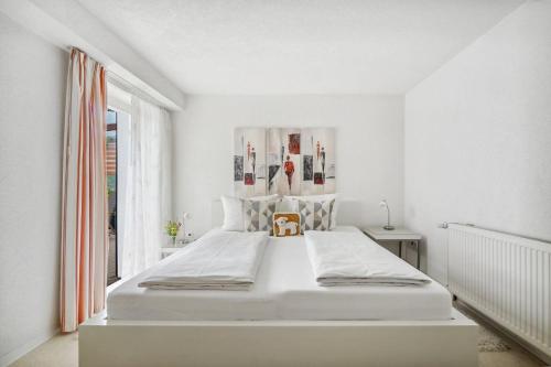 - une chambre blanche avec un grand lit et une fenêtre dans l'établissement Haus König Ferienwohnung 2 in Lichtenhain, à Sebnitz