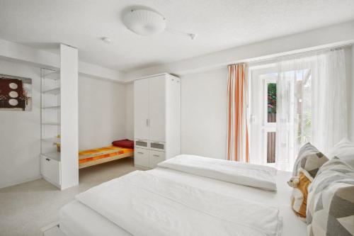 - une chambre blanche avec 2 lits et une fenêtre dans l'établissement Haus König Ferienwohnung 2 in Lichtenhain, à Sebnitz