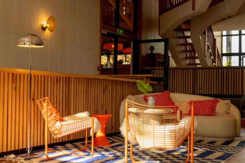 a living room with two chairs and a couch at Boutique Hôtel La Baignoire in Lacanau-Océan