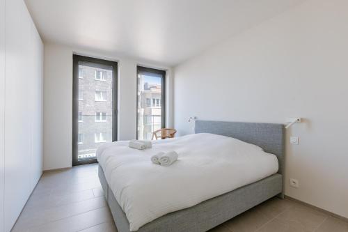 ein Schlafzimmer mit einem Bett mit zwei Handtüchern darauf in der Unterkunft Flat Leon in Koksijde