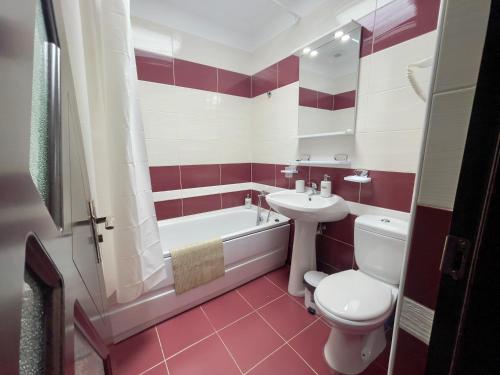 une salle de bain rouge et blanche avec des toilettes et un lavabo dans l'établissement Enjoy Apartments - Central Villa Retreat, à Cluj-Napoca