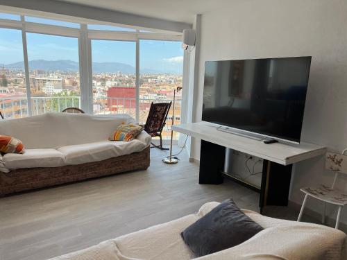 ein Wohnzimmer mit einem großen Flachbild-TV in der Unterkunft Rare find! Skyline view-Modern 6 bed 2 bath flat in the heart of Málaga in Málaga