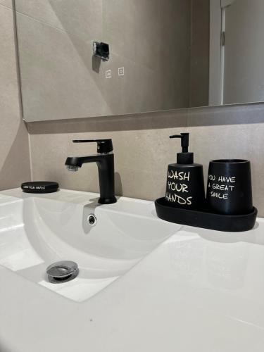 un lavandino del bagno con un rubinetto e una tazza sopra di SJ.Studio a Tirana