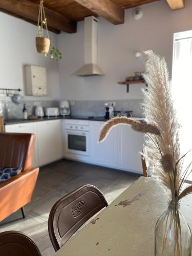 une cuisine avec une table et un vase avec une plante dans l'établissement Le Mottay Guesthouse, à Saint-Père-en-Retz