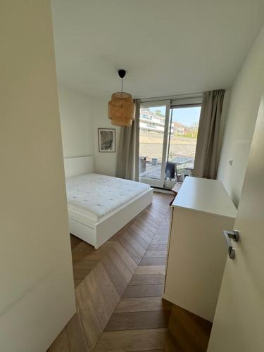 a bedroom with a bed and a large window at Old South - Luxury Apartment in Amsterdam