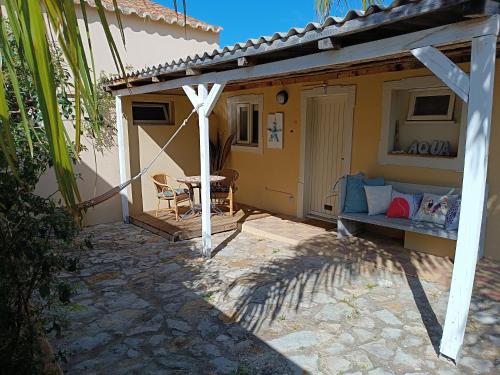 a patio of a house with a couch and a table at Quinta Pereiro Tropic Garden, Algarve in Moncarapacho