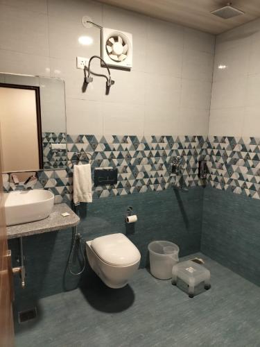 a bathroom with a toilet and a sink and a mirror at Summer Hill Resort in Chail