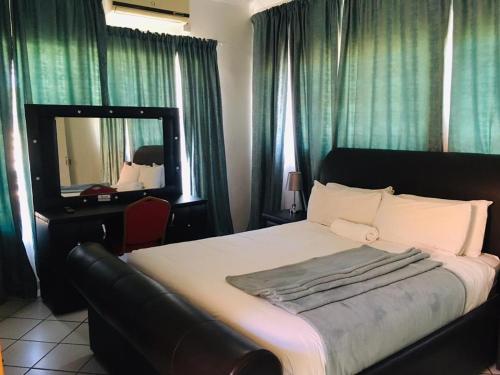 a bedroom with a large bed and a mirror at Khayalami Guest House in Mahalapye