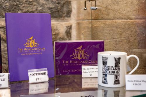 a table with two coffee mugs and a box at Courtyard Cottage 3, Riverside Cottage in Fort Augustus