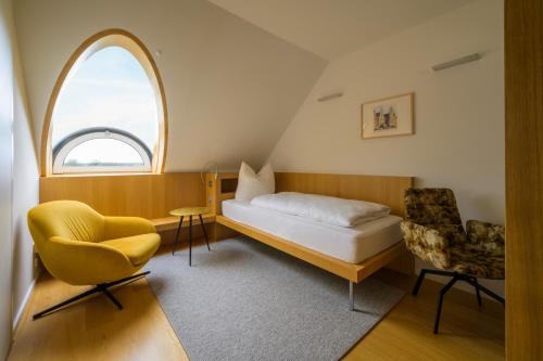 a small room with a bed and a chair at das Ox in Münster