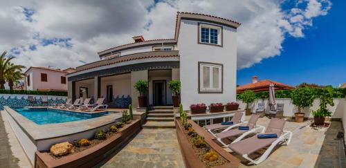 uma villa com uma piscina e espreguiçadeiras em Villa in south of Tenerife em Arona