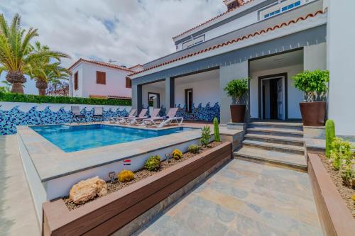 a villa with a swimming pool and a house at Villa in south of Tenerife in Costa Del Silencio