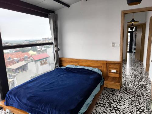 een slaapkamer met een bed en een groot raam bij Moon Village in Hanoi